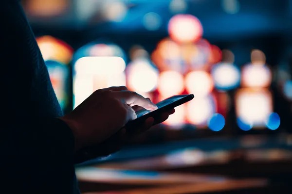A stylish woman beside vibrant slot machines displaying glowing sevens, showcasing the variety of top slots at CHEZABET.